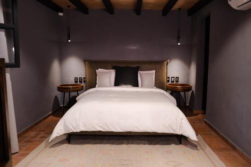 a bedroom with a large bed with two tables at Hotel Piedras Neg in San Miguel de Allende