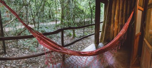 a hammock in a house in the woods at La Aldea De La Selva Lodge in Puerto Iguazú