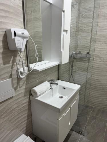 a bathroom with a white sink and a shower at Hotel Majestic in Struga