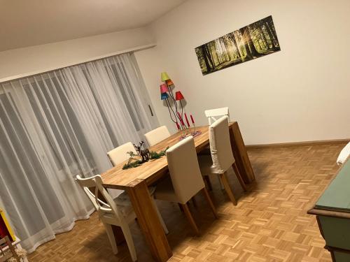 a dining room with a wooden table and chairs at Gemütliche Zimmer - nahe am EuroVisionContest in Riehen