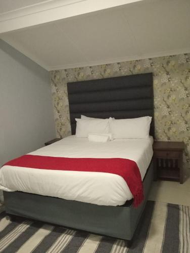 a bedroom with a large bed with a red blanket at 36 frere road shelly beach , margate in Margate