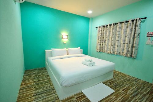 a bedroom with a white bed with a blue wall at Family House Resort in Chiang Khong