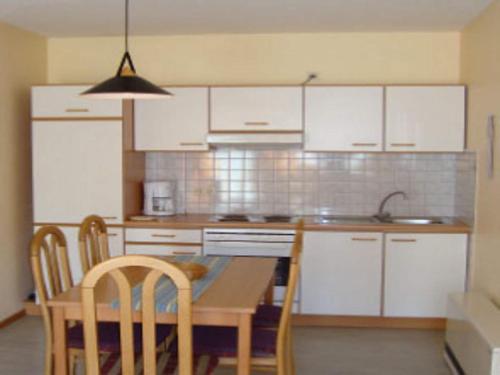 a kitchen with white cabinets and a table and chairs at Holiday Home in Germany with Terrace in Bredenborn