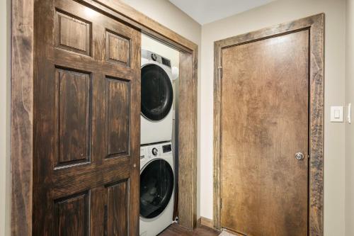 a laundry room with a wooden door and a washer and dryer at Lakeview Sunset Heaven Waterfront Escape Private Dock Firepit Game Room New Construction in Blakeslee