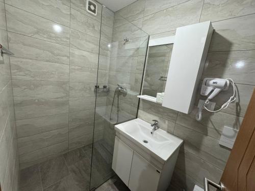 a bathroom with a sink and a shower with a mirror at Hotel Majestic in Struga