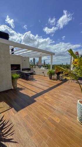 a deck with tables and chairs on a building at Acogedor departamento en Asunción in Asuncion