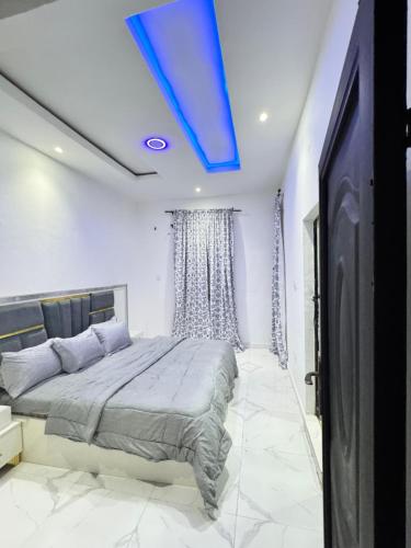 a bedroom with a bed with a blue ceiling at Sunny Service Apartment in Lagos