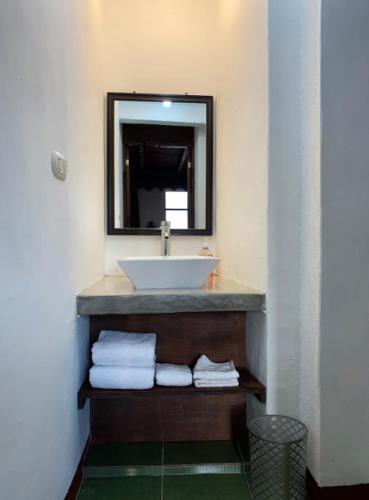a bathroom with a sink and a mirror and towels at Atitlan Sunset Lodge in Santa Cruz La Laguna