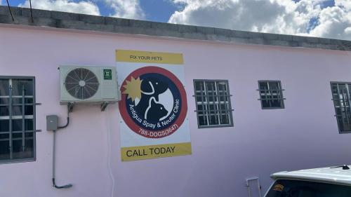 a sign on the side of a white building at Dr Fionas Animal Cottage in Saint Johnʼs