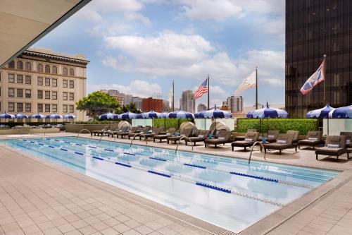 a large swimming pool with chairs and umbrellas at The Westgate Hotel in San Diego
