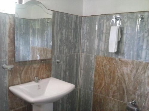 a bathroom with a sink and a mirror at Lovely lodge & Hostel in Sigiriya