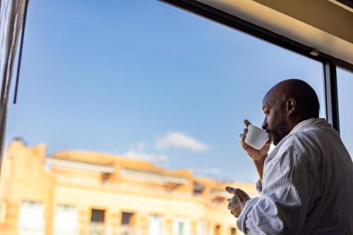 a man talking on a cell phone next to a window at Melrose Georgetown Hotel in Washington