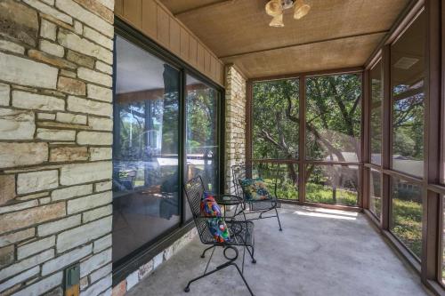 a patio with two chairs and a stone wall at Miss Lilian's House in Wimberley
