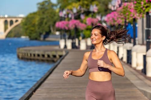 a woman running on a pier near the water at Melrose Georgetown Hotel in Washington