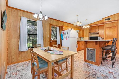 a kitchen with a table and a refrigerator at Miss Lilian's House in Wimberley