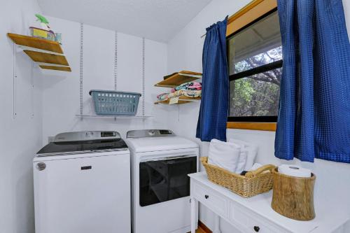 a laundry room with a washing machine and a window at Miss Lilian's House in Wimberley