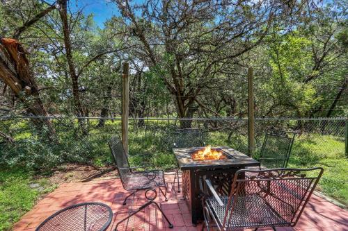 a patio with a table and chairs and a fire pit at Miss Lilian's House in Wimberley