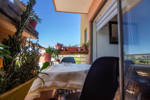 a table and chairs on a balcony with plants at Hermosa vista laguna tres Pascualas in Concepción
