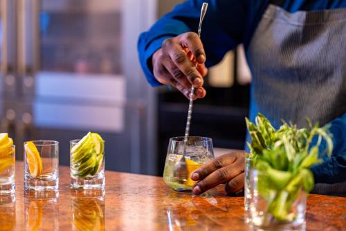 a person is stirring a drink in a glass at Melrose Georgetown Hotel in Washington