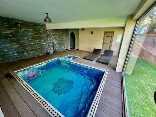 a large swimming pool in the middle of a house at Dar NFis Suites et chambres de luxe dans un havre de paix vue paradisiaque au bord du lac in Lalla Takerkoust