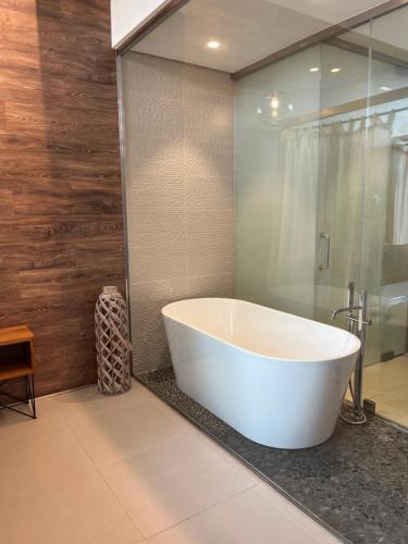 a white bath tub in a bathroom with a shower at Playa Grande by Tropical - Adults Only in Gavà