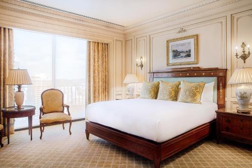 a bedroom with a bed and a chair and a window at The Westgate Hotel in San Diego