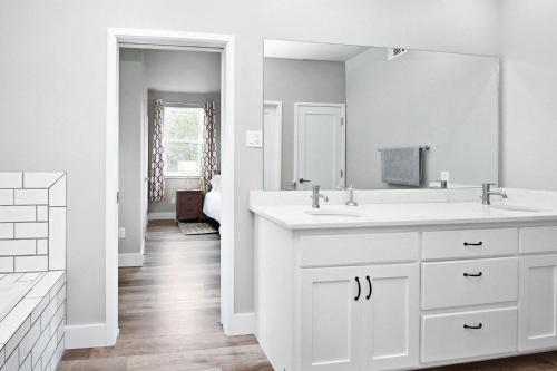 a white bathroom with a sink and a mirror at River Road Retreat in Wimberley