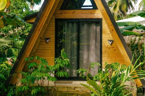 a tree house with a window in the middle at Leisy's Garden Hostel & Rooms in Santa Bárbara de Samaná