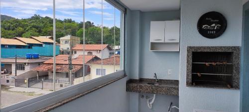 a room with a window with a view of a city at Apartamento 202 Bombinhas in Bombinhas