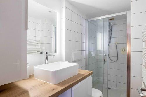 une salle de bain blanche avec un lavabo et une douche dans l'établissement Lebasque - Centre - Rue Piétonne - Annecy, à Annecy