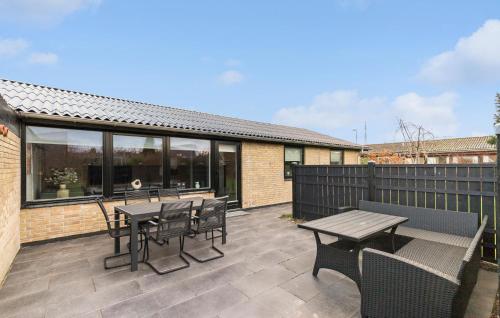a patio with tables and chairs and a fence at 2 Bedroom Stunning Home In Grenaa in Grenå