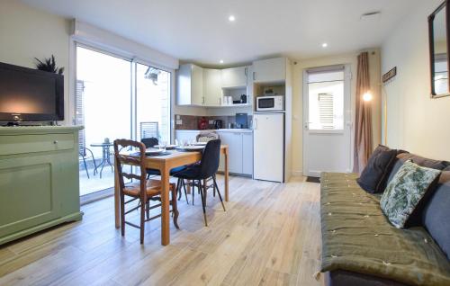 un salon avec un canapé et une table avec des chaises dans l'établissement Gorgeous Home In Esquay-Sur-Seulles, à Esquay-sur-Seulles