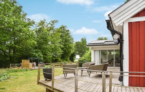 a wooden deck with chairs on a house at 3 Bedroom Amazing Home In Ronneby in Ronneby