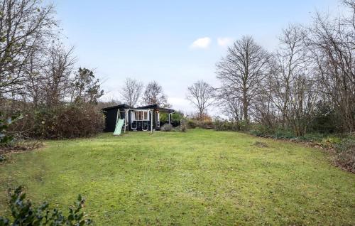 a small house in the middle of a grass field at Awesome Home In Martofte With Wifi in Martofte