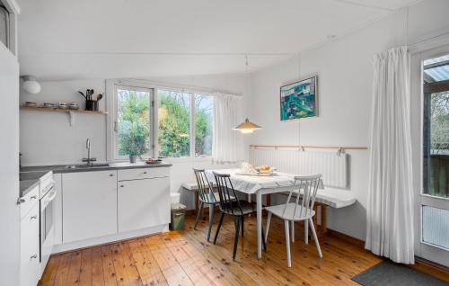 a kitchen with white cabinets and a table with chairs at Awesome Home In Martofte With Wifi in Martofte