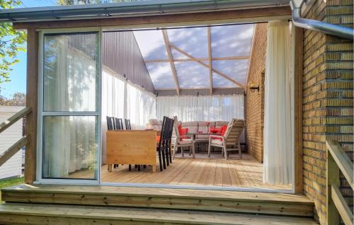a conservatory with a table and chairs on a deck at 4 Bedroom Nice Home In Färjestaden in Färjestaden