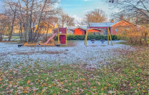 a park with a playground with a slide at 4 Bedroom Nice Home In Färjestaden in Färjestaden