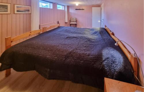 a bedroom with a large bed with a wooden frame at 4 Bedroom Nice Home In Färjestaden in Färjestaden