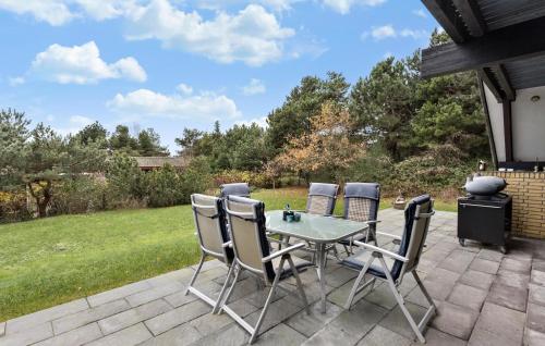 a patio with a table and chairs and a grill at 3 Bedroom Nice Home In Humble in Humble