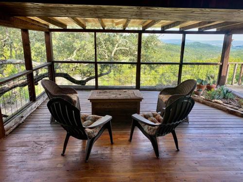 a screened in porch with two chairs and a table at La Vista in Canyon Lake