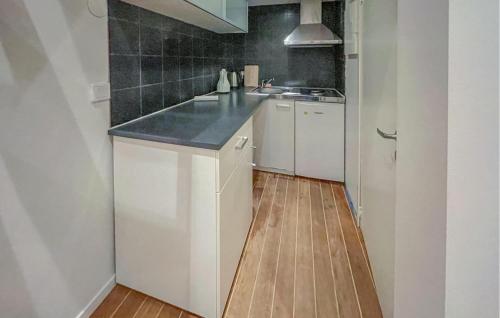 a kitchen with white cabinets and a black counter top at Gorgeous Home In Landvetter in Landvetter