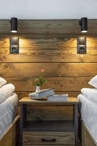a table with a vase on it next to two beds at Hotel Rzemieślnik Zakopane in Zakopane