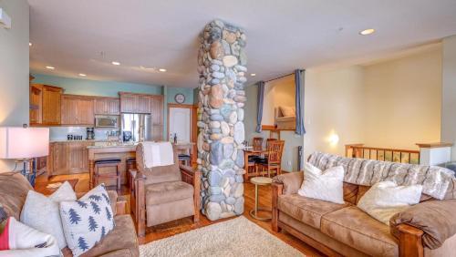 - un salon avec un canapé et un pilier en pierre dans l'établissement Gone Ski 'Inn, à Big White