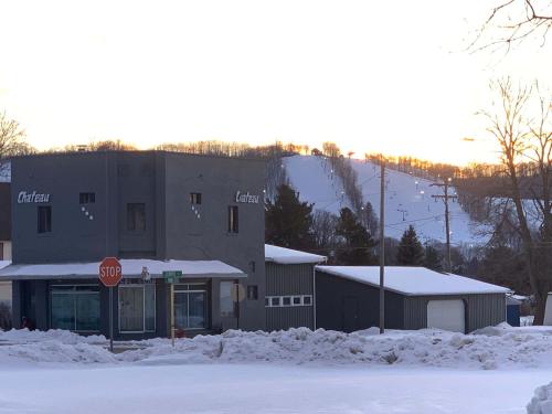 a building with a stop sign in the snow at 1 Mile From Boyne Mt- Chateau Patak in Boyne Falls