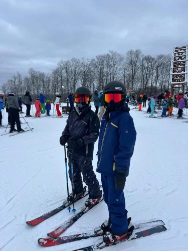 two people are standing on skis in the snow at 1 Mile From Boyne Mt- Chateau Patak in Boyne Falls
