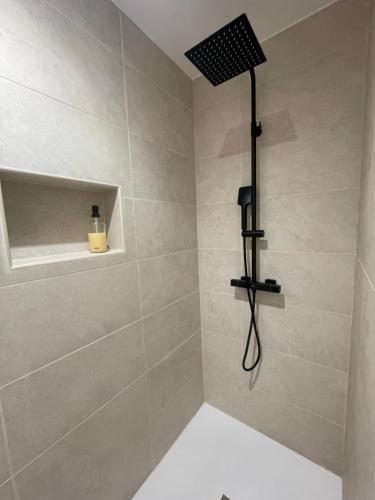 a bathroom with a shower with a black shower head at Les deux soeurs in Cholonge