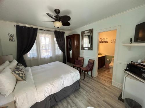 a bedroom with a bed with a ceiling fan and a desk at Arrowhead Lake Inn in Lake Arrowhead