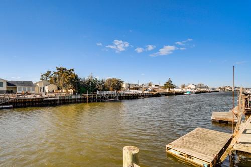 a view of a river with a dock and houses at Canal-Front Home with Dock in Little Egg Harbor! in Little Egg Harbor Township