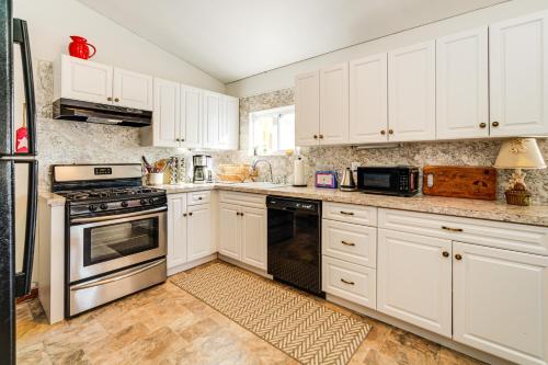 a white kitchen with white cabinets and appliances at Canal-Front Home with Dock in Little Egg Harbor! in Little Egg Harbor Township
