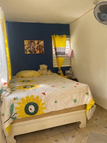 a childs bedroom with a bed with a sunflower bedspread at Rancho silvestre in Monte Plata